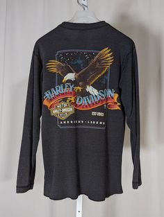 Harley Davidson 3D Emblem 80s Vintage Buffalo Henley 5050 Shirt Eagle M Oregon. Check out my other Harley t shirt listings. Cool two sided Harley graphic printed on high quality 5050 henley. Some fading and faint blemishes, but overall great vintage condition. Pit to pit: 18" Length: 24" Shoulders: 18" Shoulder to cuff: 21" Retro Embroidered Streetwear Tops, Retro Embroidered Graphics Tops For Streetwear, Retro Tops With Embroidered Graphics For Streetwear, Retro Embroidered Tops For Streetwear, Vintage Graphic Print Winter Top, Vintage Long Sleeve Top With Graphic Print, Fitted Long Sleeve Tops With Embroidered Graphics, Vintage Crew Neck Top With Embroidered Graphics, Retro Tops With Embroidered Graphics For Winter