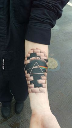 a person with a pink floyd tattoo on their arm