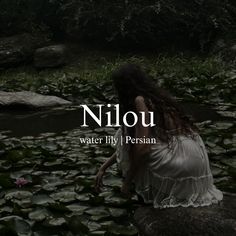 a woman sitting on top of a rock next to water lilies