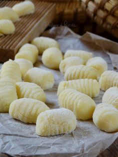 several pieces of bread sitting on top of a piece of wax paper next to bamboo baskets