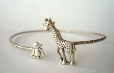 I handcrafted this bracelet using a vintage metal delicate bracelet base, a silver plated giraffe and a silver plated penguin. The parts are soldered and not glued.The bracelet is adjustable.It comes in a gift box. Extra little GIFT included separately with the packaging!More Rings selection: www.etsy.com/shop/stavri?section_id=7346628More Bracelets selection: www.etsy.com/shop/stavri?section_id=7133840More Necklaces selection: www.etsy.com/shop/stavri?section_id=6926501For more jewelry designs, Unique Metal Charm Bracelet As Gift, Unique Adjustable Metal Charm Bracelet, Adjustable Unique Metal Charm Bracelet, Cute Silver Charm Bracelet Bangle, Cute Silver Bangle Charm Bracelet, Unique Nickel-free Charm Bracelet As Gift, Unique Nickel-free Charm Bracelet, Unique Nickel Free Charm Bracelet, Unique Sterling Silver Charm Bracelet Gift