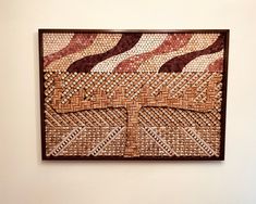 a wall hanging on the side of a white wall with a brown and tan pattern