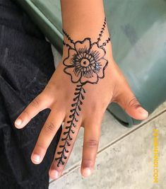 a woman's hand with a flower tattoo on it