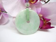 "This beautiful purple woven string coupled with the Jade bead's necklace which comes with a handcrafted Grade AAA natural light green Jade Donut (平安扣) as an auspicious symbol of peace and safety and will protect the wearer against evil. The Grade AAA natural light green Jade Donut (平安扣) measures approximately 2\" dia. x 1/4\" thickness (4.9cm dia. x 0.6cm). The total weight of the necklace is 33g. The necklace comes with an adjustable woven string with its shortest at approximately 20\" and can Handmade Jade Necklaces For Good Luck, Green Amulet Round Necklace, Green Round Amulet Necklace, Green Amulet Style Round Necklace, Handmade Symbolic Green Necklace, Green Beaded Necklace With Large Pendant For Gift, Green Beaded Necklaces With Large Pendant For Gift, Spiritual Jade Beaded Necklace, Spiritual Round Jade Beaded Necklace