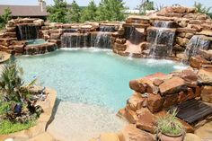 an outdoor pool with waterfall and seating area