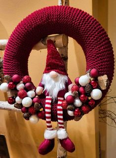 a christmas wreath is hanging on a pole with santa's hat and ornaments around it