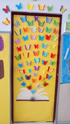 an open book sitting on top of a table next to a wall with butterflies painted on it