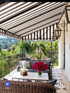 an outdoor living area with wicker furniture and large potted plants on the balcony