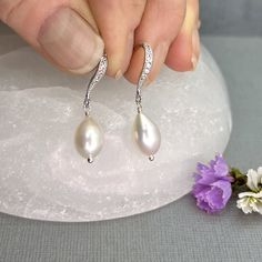 "✦These lustrous white teardrop-shaped natural freshwater pearls earrings are the perfect gift from mom for the Bride-To-Be for her wedding day, or from the bride for her special bridesmaid or maid of honor.   ✦Natural freshwater pearls are creamy white, high quality, and lustrous, measuring 10 x 7mm. ✦They come with your choice of CZ lined leverback ear wires, or beautiful shapely hook ear wires.  Both are made of all sterling silver, with tiny cubic zircona stones embedded in the surface. Plea Elegant Pear-shaped Pearl Earrings For Anniversary, Pear-shaped Pearl Drop Bridal Earrings In White Gold, Graceful Teardrop Pearl Charm Earrings, Elegant Silver Pearl Earrings With Pear Shape, Elegant Pear-shaped Teardrop Earrings As Gift, Elegant Silver Pear-shaped Pearl Earrings, White Gold Pear-shaped Earrings For Wedding, White Gold Pear-shaped Wedding Earrings, Pear-shaped White Gold Wedding Earrings