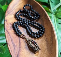 "☾ Created with genuine, Ethically-sourced gemstones:  BLACK ONYX  Courage, Strength, Resiliency, Release of the Old & New Beginnings This artisan mala was lovingly handcrafted with: - Matte Black Onyx 8mm beads, Natural & Ethically-Sourced - Vintage Brass Kuan Yin/Guan Yin Bodhisattva of Compassion Amulet, Thailand - Hematite & Garnet Tassels, Fair Trade Ethiopian Brass & Copper accents This mala features 108 beads, hand-knotted in traditional style between each bead. The beads are each 8mm in Spiritual Black Beaded Necklaces, Black Spiritual Beaded Necklaces, Black Spiritual Beads For Meditation, Spiritual Black Beads Mala For Meditation, Spiritual Black Beaded Necklaces For Meditation, Black Spiritual Mala For Healing, Onyx Beaded Necklaces For Meditation, Onyx Black Beaded Necklace For Meditation, Spiritual Obsidian Necklaces For Meditation