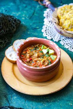 a bowl of soup with bread on the side