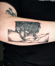 a man with a tattoo on his arm reading a book