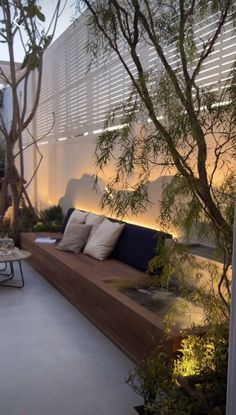 an outdoor living area with couches, tables and plants on the side walk way