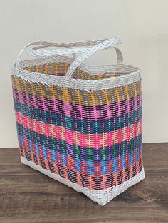 a multicolored basket sitting on top of a wooden table