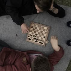 two people sitting on the ground playing chess