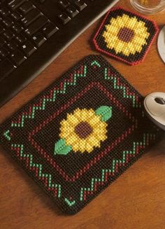 a computer keyboard sitting on top of a wooden desk next to a knitted place mat