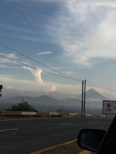 there is a sign on the side of the road with mountains in the back ground