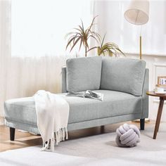 a gray couch sitting on top of a white rug