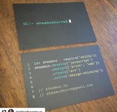 two business cards sitting on top of a wooden table next to each other with code printed on them