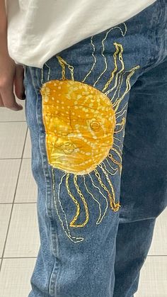 a person wearing blue jeans with yellow jellyfish on them