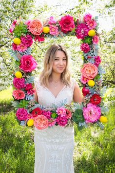 a woman standing in front of a floral frame