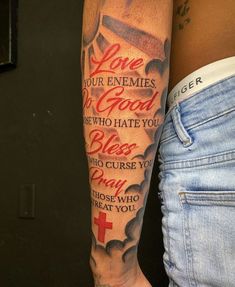 a woman's arm with a cross and bible verse tattooed on the side of her leg