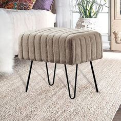 a grey foot stool sitting on top of a rug