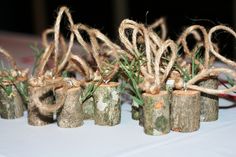 several small wooden logs tied with twine on a white table cloth covered tablecloth