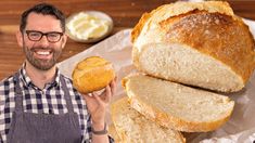 a man holding a loaf of bread in front of it