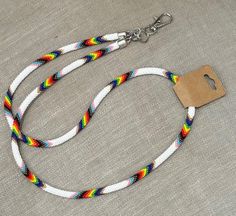 a white and multicolored rope with a brown tag on it is sitting on a gray surface