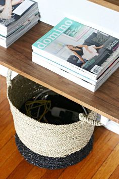 a table with books and magazines sitting on it's shelf next to a magazine rack