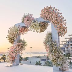 an outdoor wedding setup with flowers and greenery on the top floor, overlooking the ocean