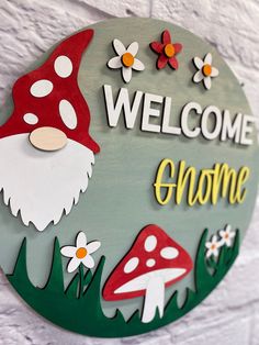 a welcome sign with mushrooms and flowers on it