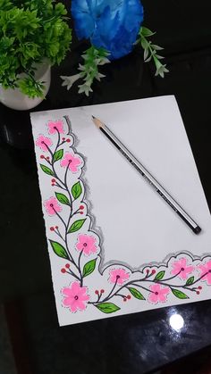 a piece of paper with flowers on it next to a pencil and potted plant