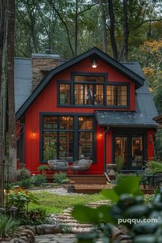 a red house in the woods surrounded by trees