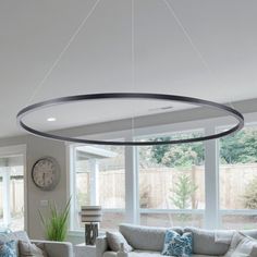 a living room filled with furniture and a large round light fixture hanging from the ceiling