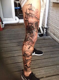 a man's leg with a ship tattoo on it