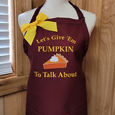 an apron that says let's give em pumpkin to talk about with a cupcake on it