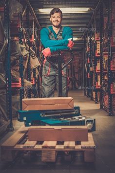 a man standing in a warehouse with his arms crossed - stock photo - images