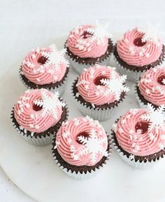 cupcakes with pink frosting and white sprinkles on a plate