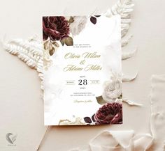 a wedding card with flowers and leaves on it