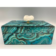 a blue and green box with a white flower on top