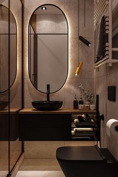 a modern bathroom with an oval mirror above the sink and black basin on the counter