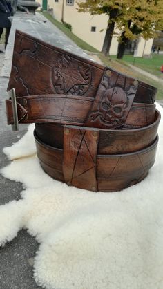 two wooden belts sitting on top of a pile of white sheepskin covered flooring