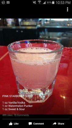 a glass filled with liquid sitting on top of a red table