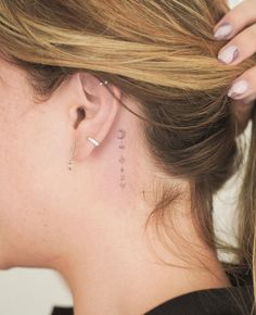 a woman with a small tattoo behind her ear