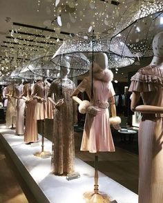 mannequins dressed in dresses and umbrellas on display