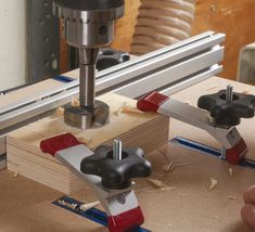 a machine that is working on some wooden planks with two holes in the middle