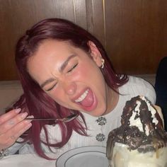 a woman with red hair is eating an ice cream sundae