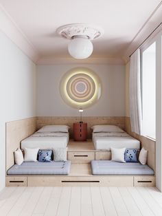 two beds sitting next to each other in a room with white walls and wooden floors